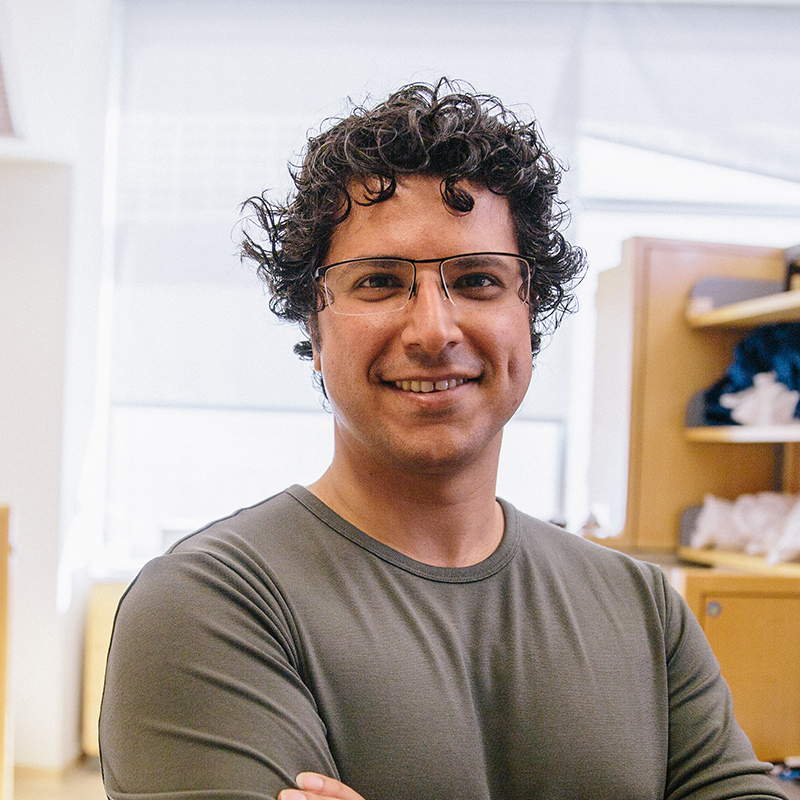 Hani Goodarzi, arms folded, smiling in his lab.